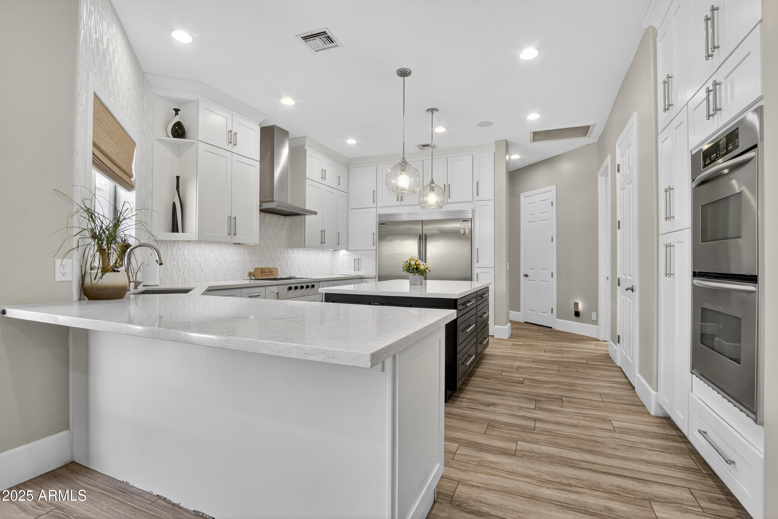 1333 North Cliffside Drive Gilbert, AZ 85234 - Photo 24 of 100 a large kitchen with stainless steel appliances lots of counter space and wooden floor