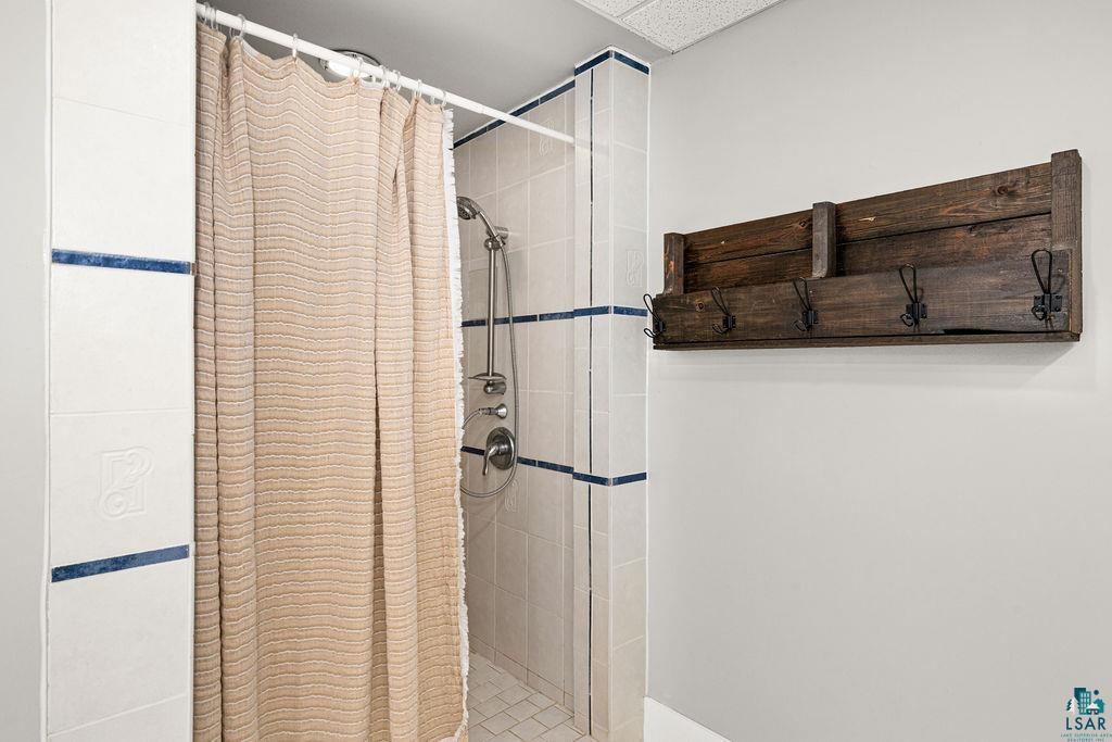5025 Reid Road Duluth, MN 55803 - Photo 33 of 51 Tiled shower stall with a showerhead and separate handheld sprayer