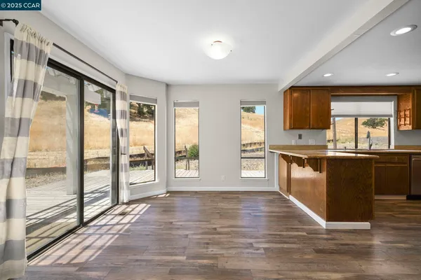 a view of open kitchen with granite countertop a stove top oven a sink and dishwasher with wooden floor