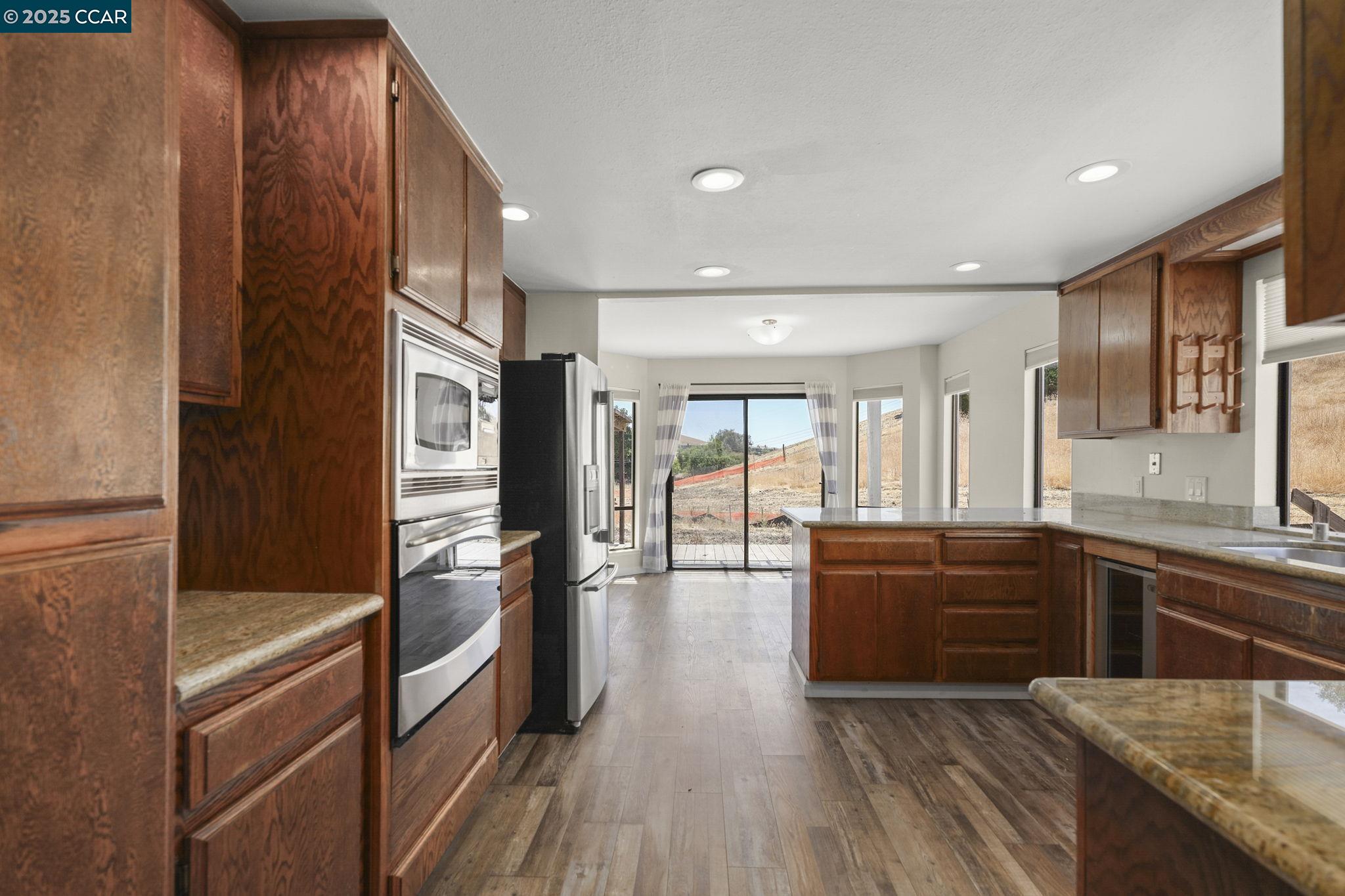 1610 Lawrence Road Danville, CA 94506 - Photo 23 of 36 a kitchen with stainless steel appliances granite countertop a refrigerator a sink dishwasher and wooden cabinets with wooden floor