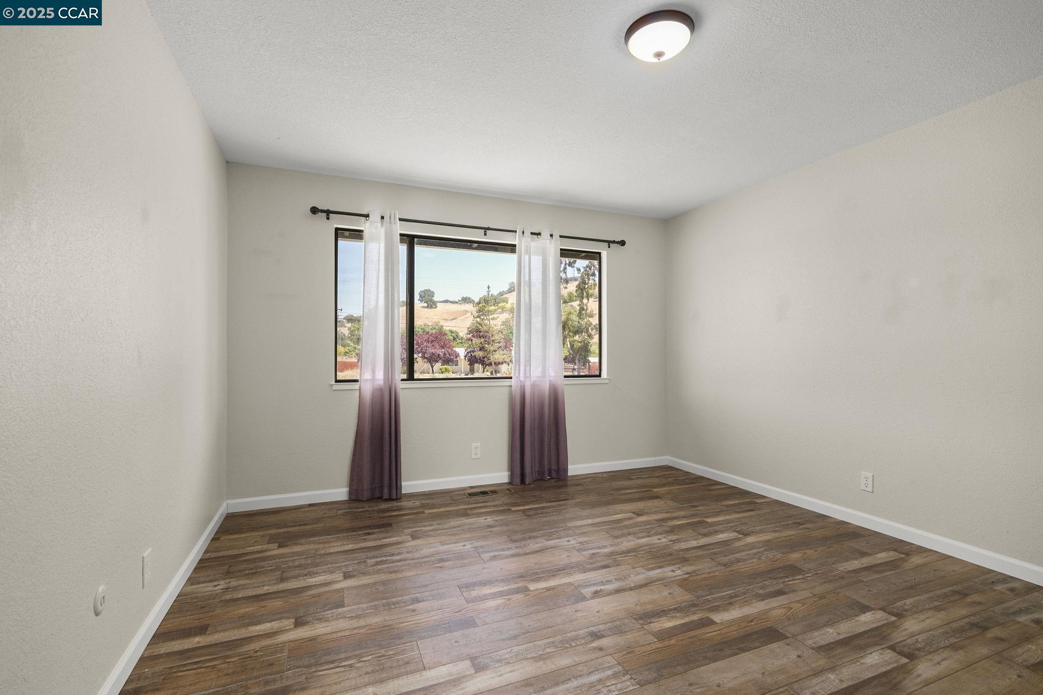 1610 Lawrence Road Danville, CA 94506 - Photo 27 of 36 an empty room with wooden floor and windows