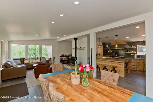 a living room with furniture dining table a chandelier and a flat screen tv