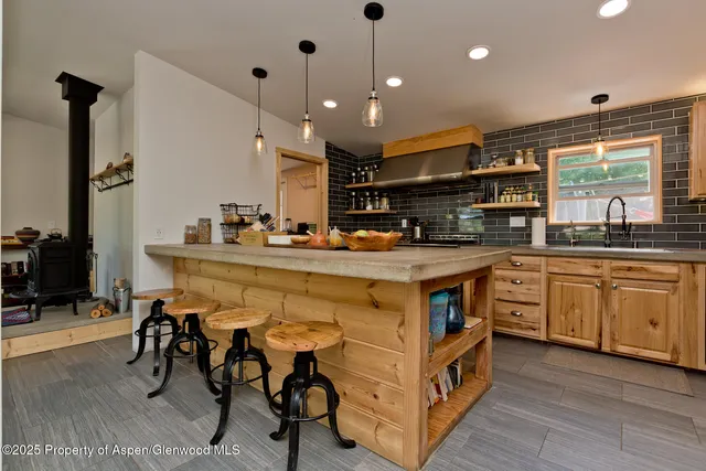 a kitchen with stainless steel appliances granite countertop a sink a stove and a refrigerator