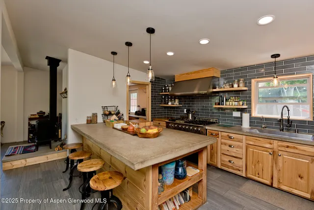 a kitchen with sink stove and chairs