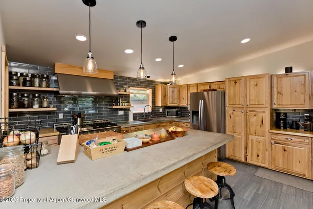 a kitchen with stainless steel appliances granite countertop a sink a stove and a refrigerator