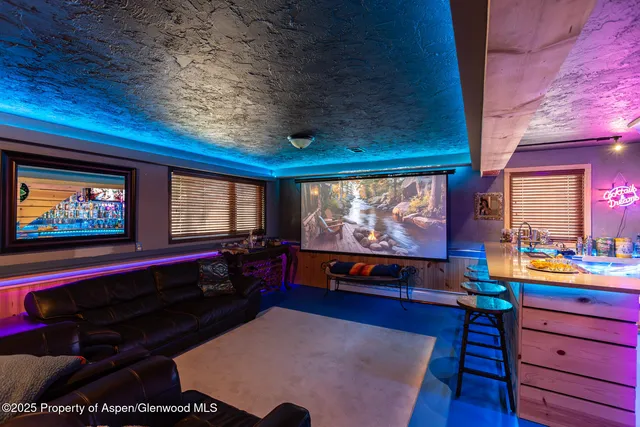 a living room with furniture a rug and a floor to ceiling window