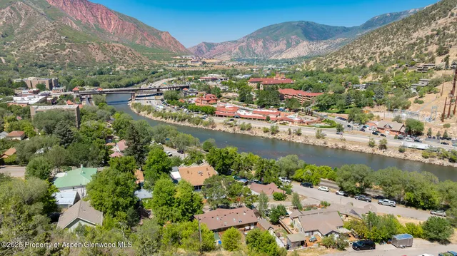 an aerial view of residential houses with outdoor space and trees
