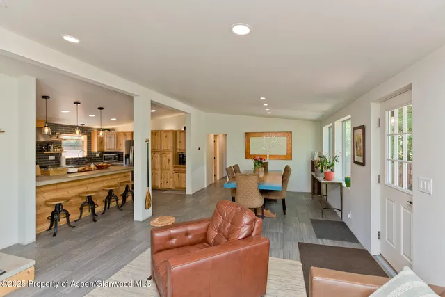 a living room with furniture kitchen view and a refrigerator
