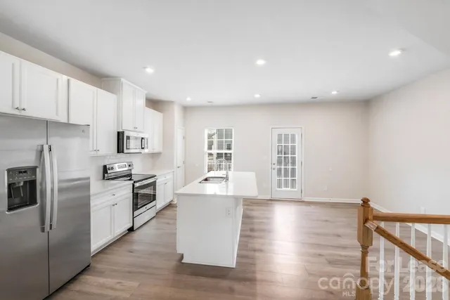 a kitchen with cabinets and wooden floor