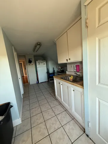 a kitchen with granite countertop a stove a sink and a refrigerator
