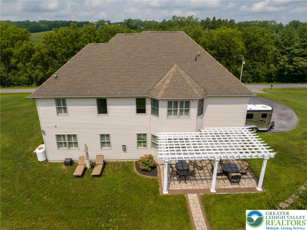 217 Gower Road Nazareth, PA 18064 - Photo 8 of 44 An inviting backyard patio with a white pergola offers a perfect spot for outdoor dining and relaxation.