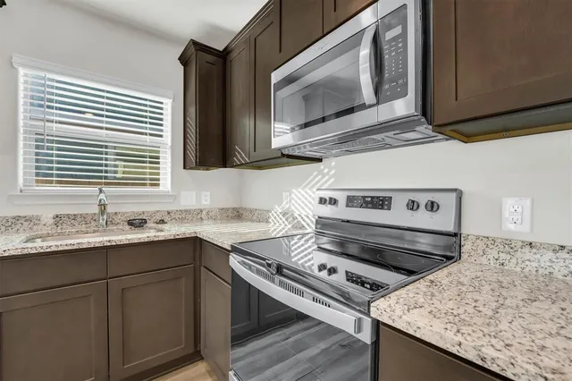 a kitchen with a stove microwave and sink