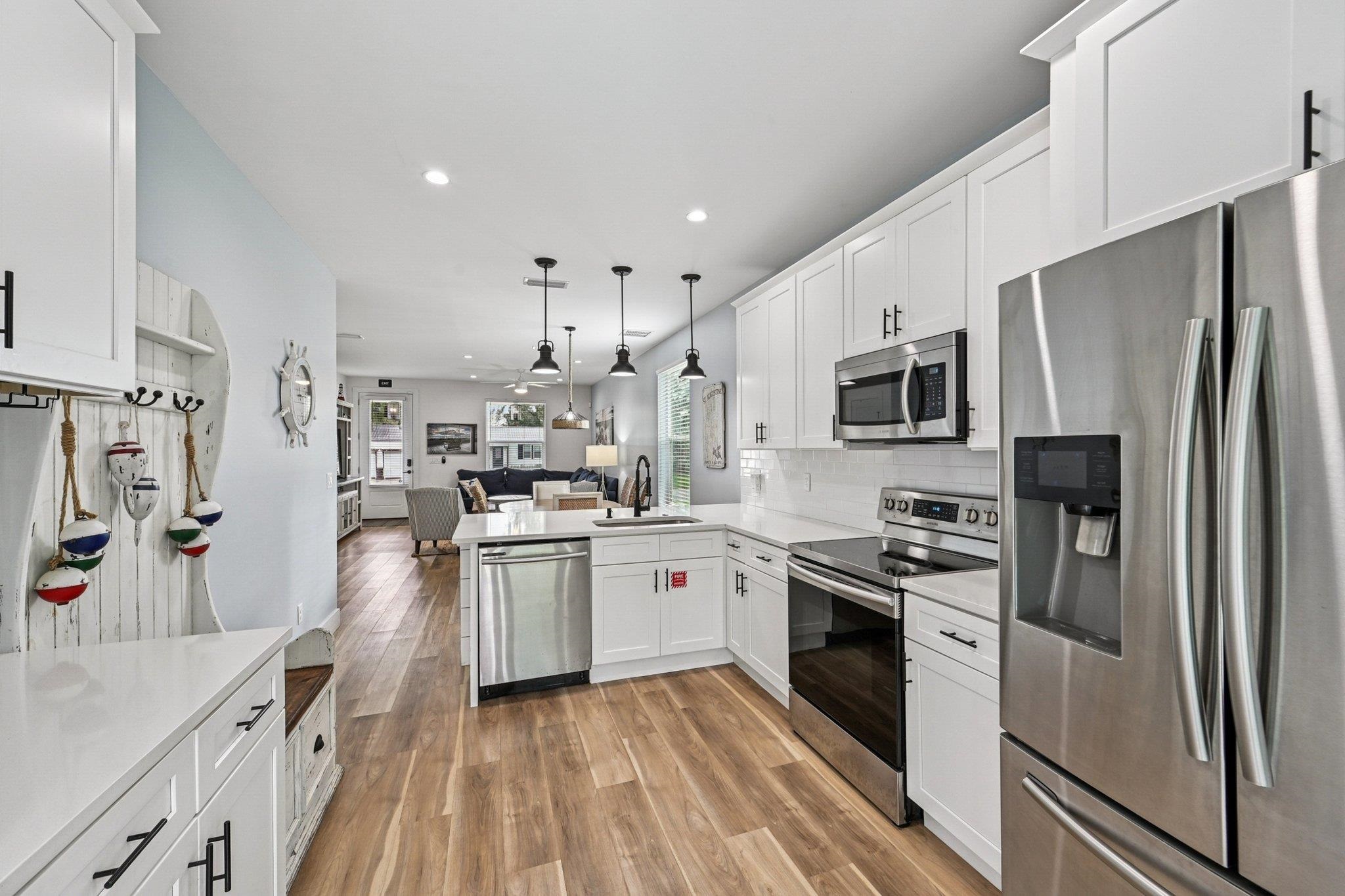 43 Menendez Road St. Augustine, FL 32080 - Photo 45 of 48 Kitchen with stainless steel appliances, open floor plan, white cabinetry, pendant lighting, and light wood-type flooring