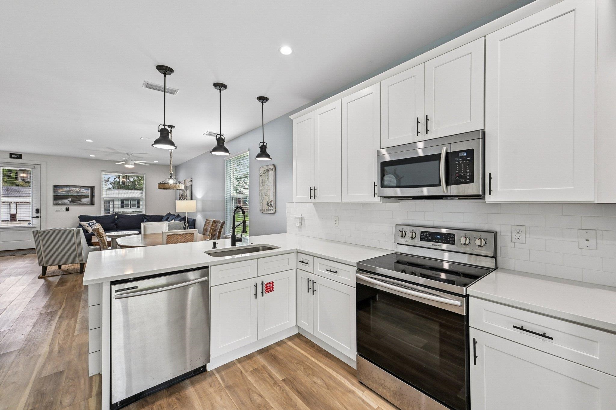 43 Menendez Road St. Augustine, FL 32080 - Photo 46 of 48 Kitchen featuring stainless steel appliances, pendant lighting, open floor plan, white cabinets, and tasteful backsplash
