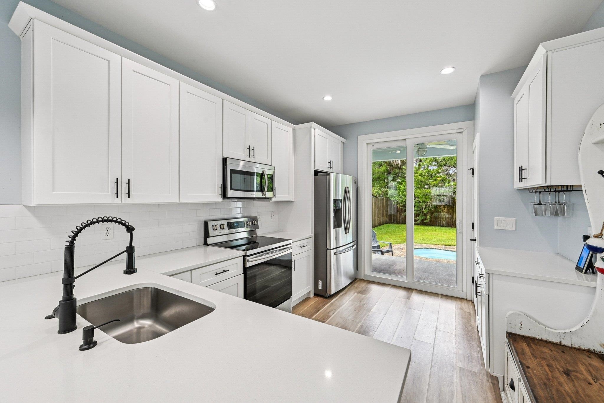 43 Menendez Road St. Augustine, FL 32080 - Photo 15 of 48 Kitchen featuring white cabinetry, appliances with stainless steel finishes, tasteful backsplash, light wood finished floors, and recessed lighting