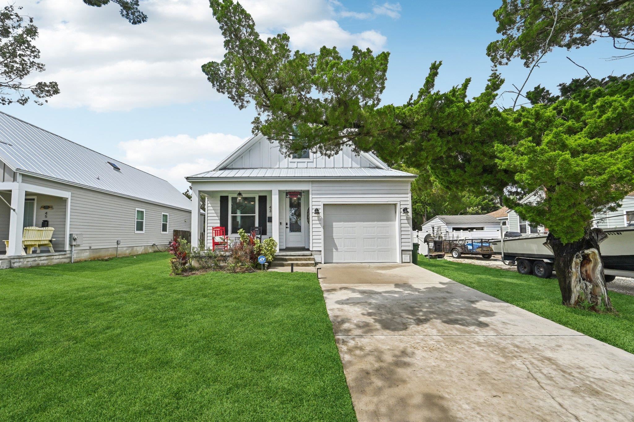 43 Menendez Road St. Augustine, FL 32080 - Photo 3 of 48 View of front facade featuring driveway, covered porch, a front lawn, and a garage
