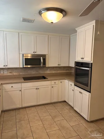 a kitchen with granite countertop white cabinets a sink and dishwasher