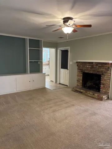 a view of an empty room with a fireplace and a window