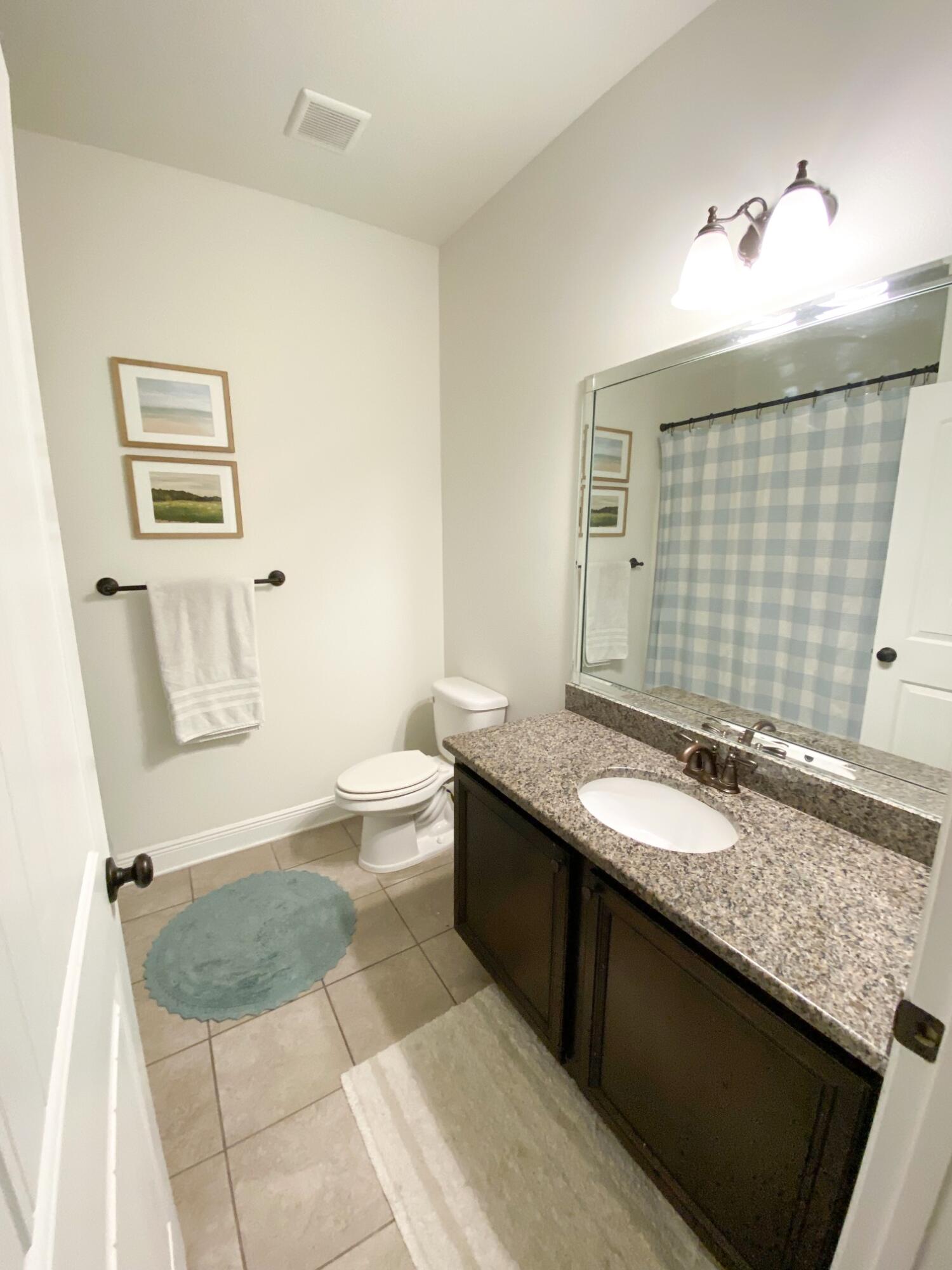 285 Maddox Street Santa Rosa Beach, FL 32459 - Photo 15 of 35 a bathroom with a granite countertop sink a toilet a mirror and bathtub