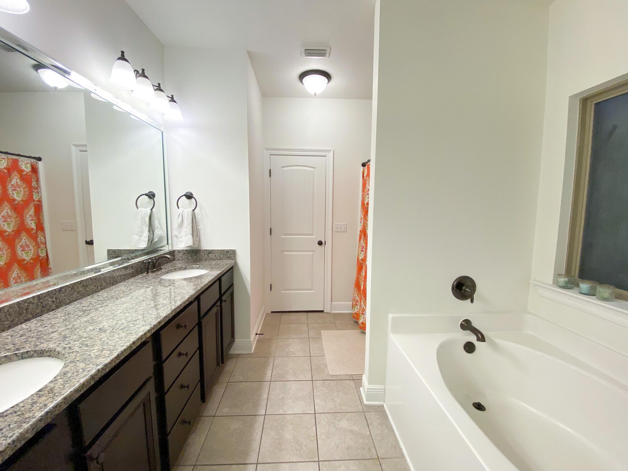 285 Maddox Street Santa Rosa Beach, FL 32459 - Photo 26 of 35 a spacious bathroom with a granite countertop tub sink and mirror