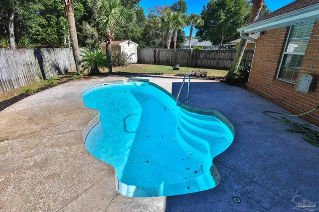 a view of a backyard with couches and wooden fence