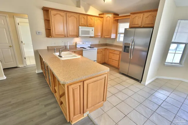 a kitchen with stainless steel appliances granite countertop a refrigerator a sink and a stove