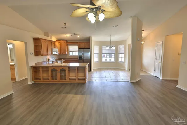 a room with wooden floor and large kitchen view