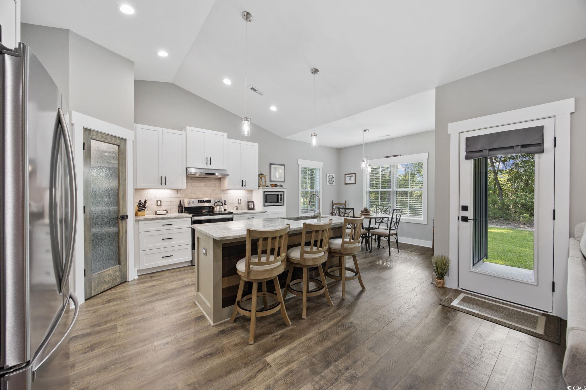 4446 Boggy Road Conway, SC 29526 - Photo 9 of 25 Kitchen featuring stainless steel appliances, under cabinet range hood, wood finished floors, a center island with sink, and lofted ceiling