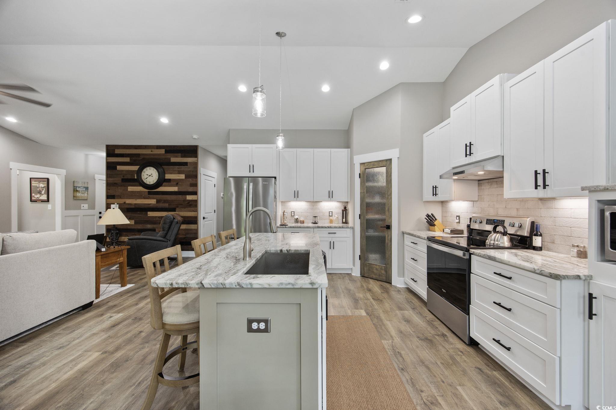 4446 Boggy Road Conway, SC 29526 - Photo 25 of 25 Kitchen featuring appliances with stainless steel finishes, under cabinet range hood, a breakfast bar area, open floor plan, and backsplash
