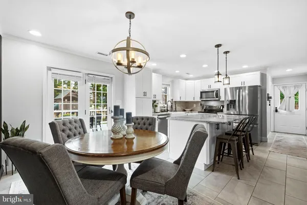 a dining room with furniture a chandelier and wooden floor