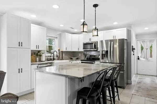 a kitchen with stainless steel appliances granite countertop a sink stove microwave and refrigerator