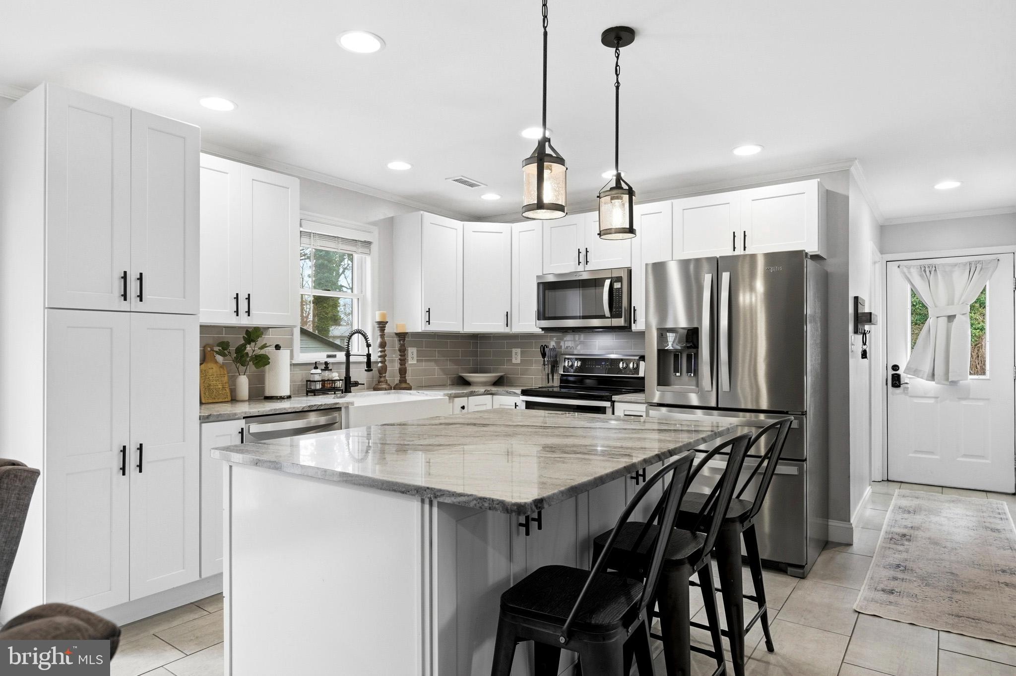 3930 Dogwood Road Port Republic, MD 20676 - Photo 15 of 48 a kitchen with stainless steel appliances a stove a sink a refrigerator a microwave oven a stove a dining table and chairs