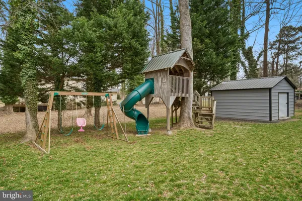 a wooden bench sitting in the middle of a yard