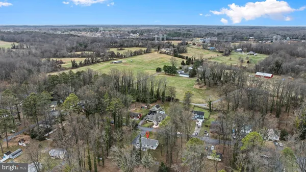 an aerial view of residential house with outdoor space and trees all around