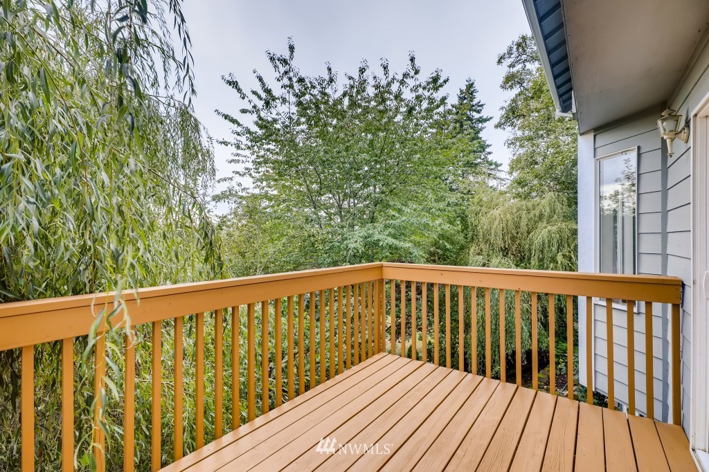 16648 Sylvester Road Southwest Burien, WA 98166 - Photo 12 of 36 a balcony with wooden floor and trees in the background