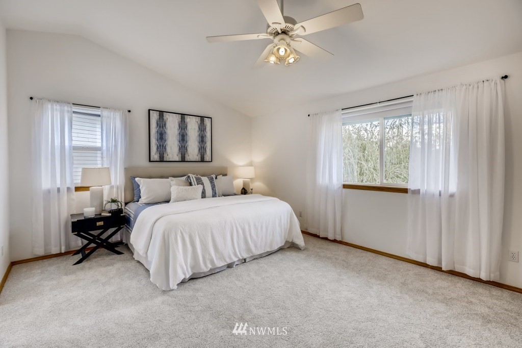 16648 Sylvester Road Southwest Burien, WA 98166 - Photo 16 of 36 a spacious bedroom with a bed and a chandelier