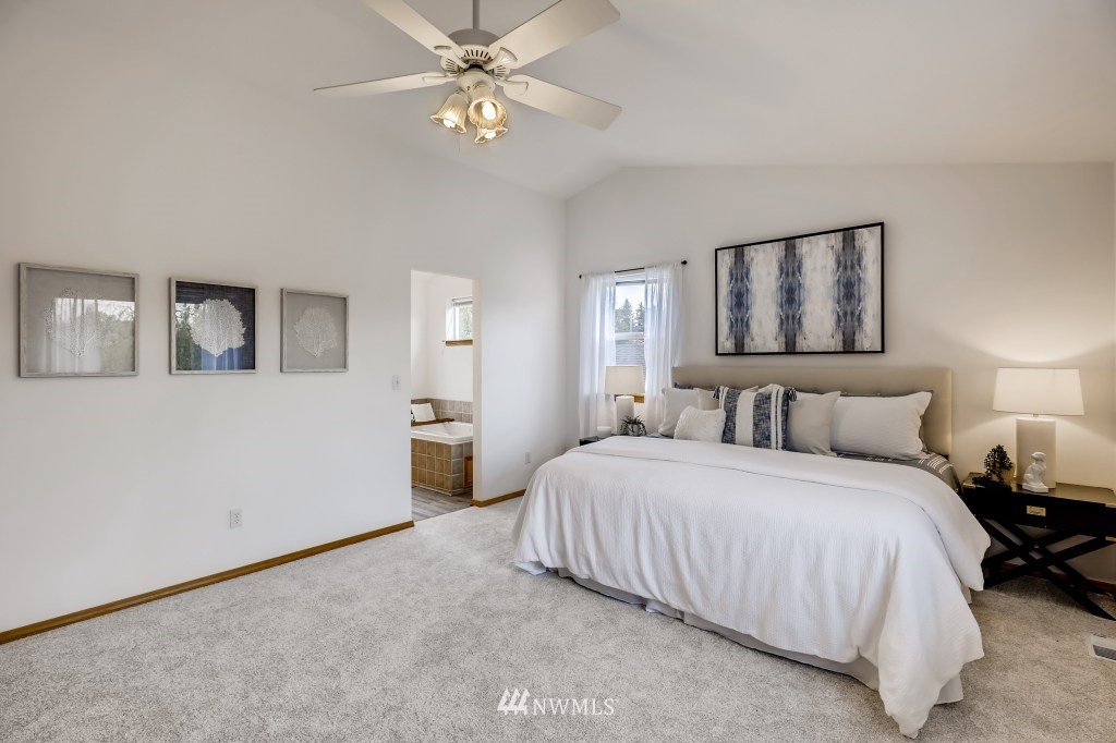 16648 Sylvester Road Southwest Burien, WA 98166 - Photo 17 of 36 a bedroom with a large bed and a chandelier