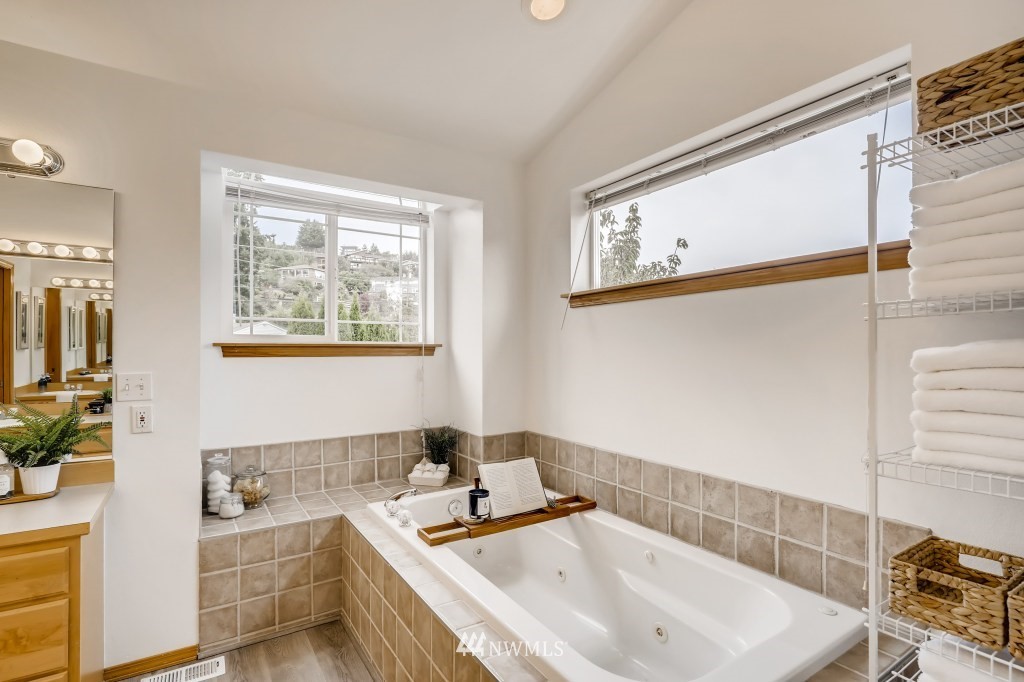 16648 Sylvester Road Southwest Burien, WA 98166 - Photo 20 of 36 a bathroom with a double vanity sink a mirror and a bathtub