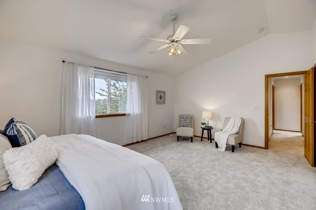16648 Sylvester Road Southwest Burien, WA 98166 - Photo 21 of 36 a bedroom with a large bed and a chandelier