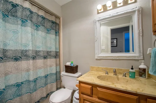 a bathroom with a granite countertop sink toilet and shower