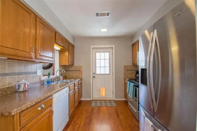 a kitchen with stainless steel appliances granite countertop a refrigerator and a sink