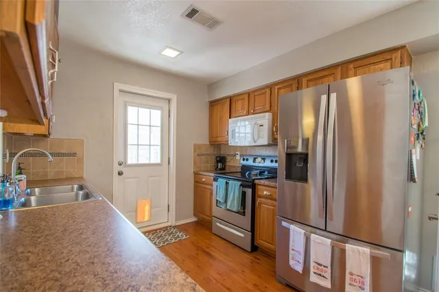 a kitchen with stainless steel appliances granite countertop a refrigerator stove and sink