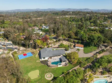 an aerial view of residential house with outdoor space and trees
