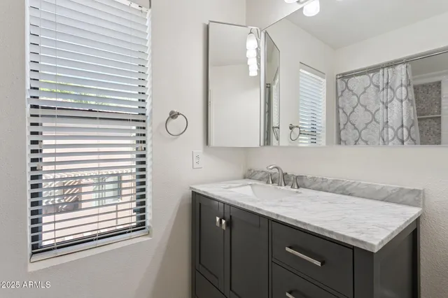 a bathroom with a granite countertop sink and a mirror