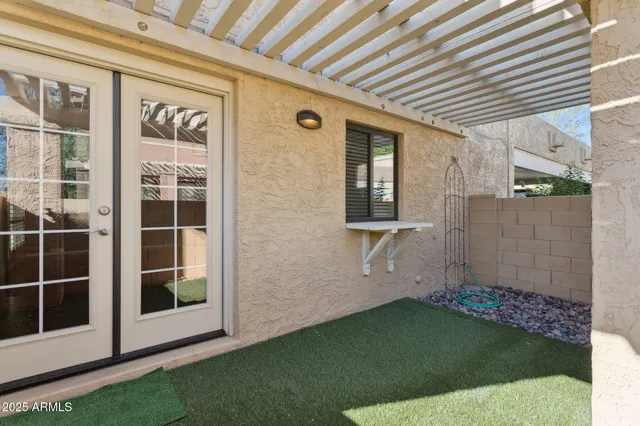 a view of swimming pool with lawn chairs and plants