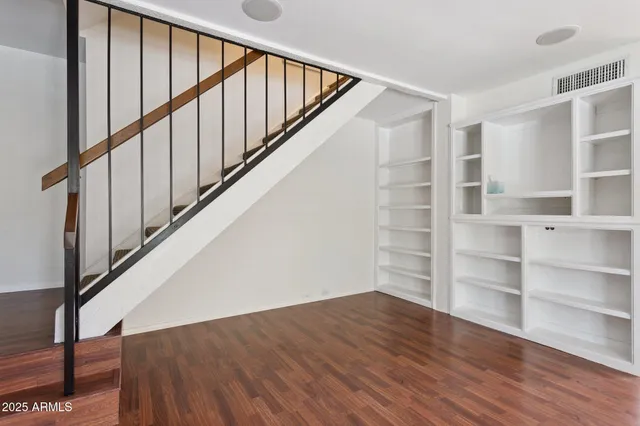 a view of staircase with wooden floor and white walls