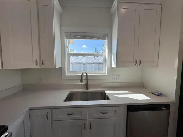 a kitchen with a sink cabinets and window