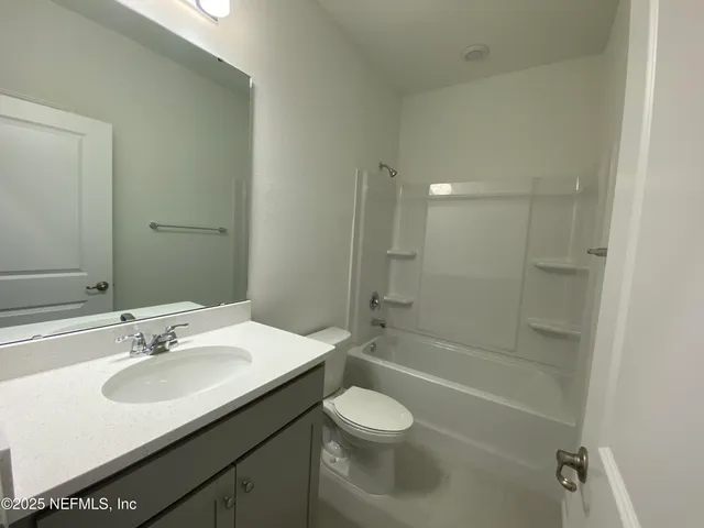 a large kitchen with stainless steel appliances a refrigerator and a wooden floor