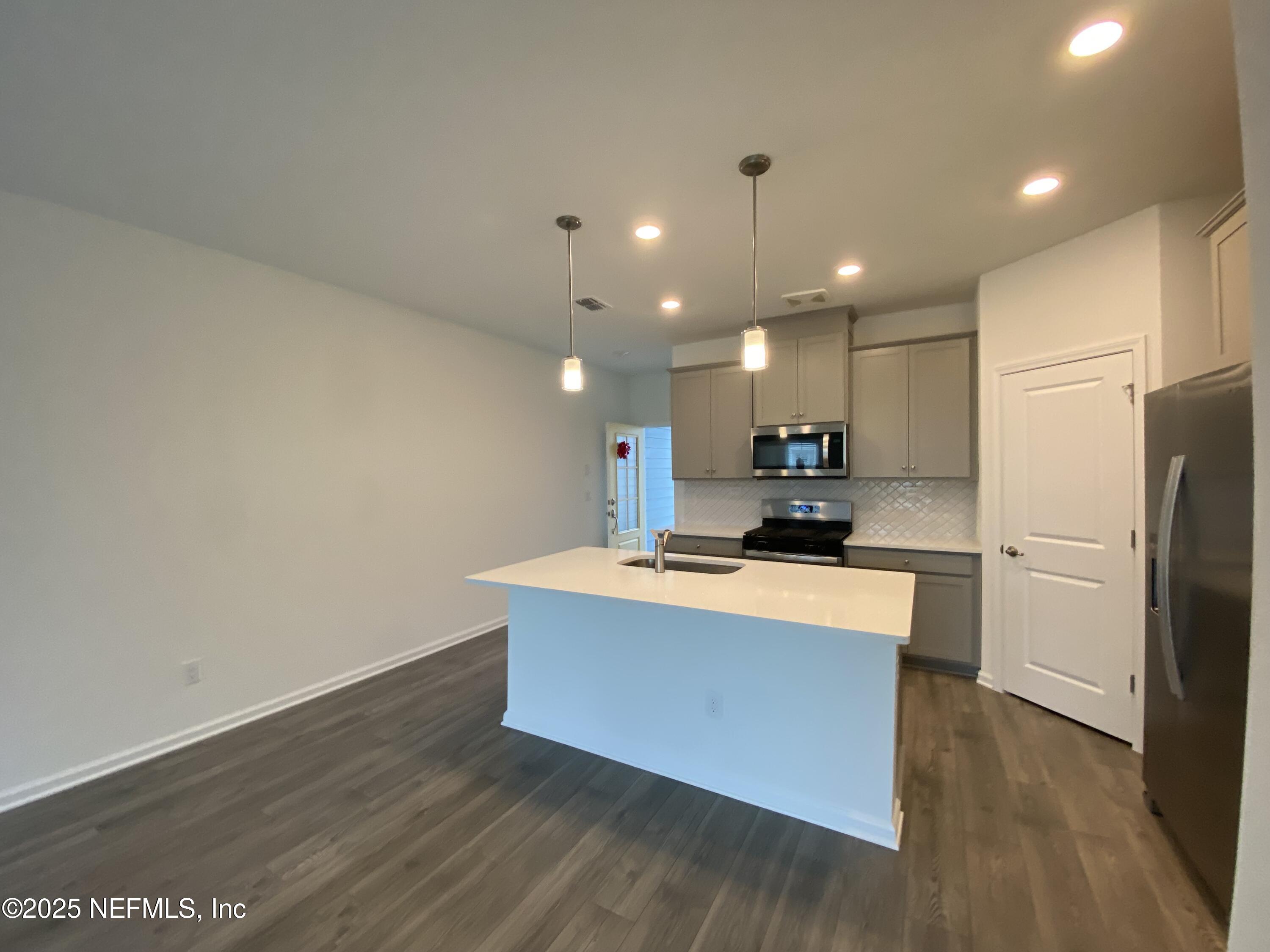 269 Brandon Lks Drive St. Augustine, FL 32092 - Photo 14 of 16 a kitchen with kitchen island a sink a stove a refrigerator and a oven with wooden floor