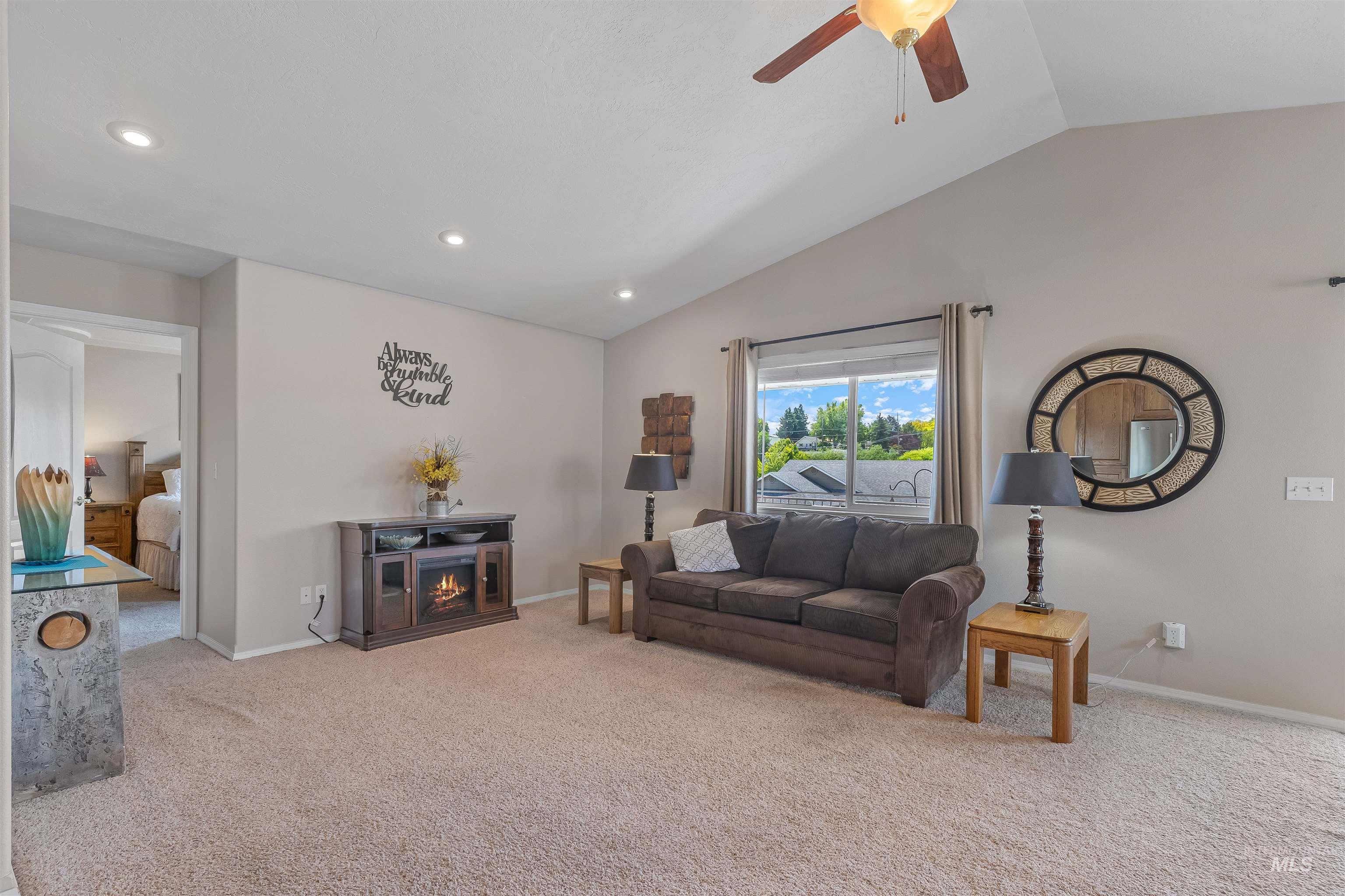 935 Grelle Avenue Lewiston, ID 83501 - Photo 12 of 33 Living room featuring lofted ceiling, carpet floors, ceiling fan, recessed lighting, and a lit fireplace